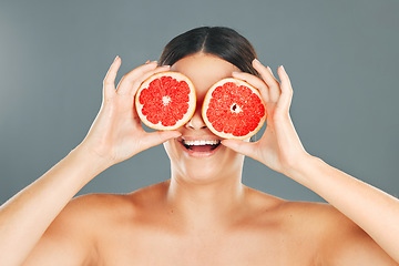 Image showing Fruit eyes, woman and beauty model with grapefruit for skincare, wellness and health. Studio background, young person and happiness holding healthy food for vitamin c, diet and dermatology support