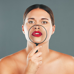 Image showing Beauty, magnifying glass and portrait of a woman in studio with a makeup, skincare and natural routine. Face, cosmetic and female model with glass lens on her mouth while isolated by gray background.