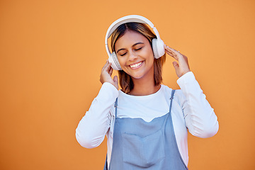 Image showing Wall, mockup and woman with headphones, music and relax with confident girl on studio background. Young female, lady and headset for podcast, radio and audio with sounds, streaming and listen to song