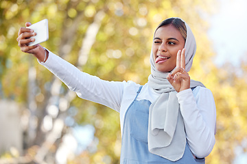 Image showing Selfie, peace and Islamic woman outdoor, silly face or confident with casual outfit, happiness or joy. Muslim female, lady in nature or smartphone to share photo, social media or connection with sign