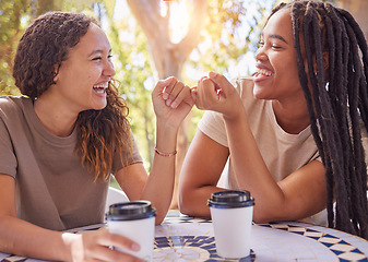 Image showing Happy, pinky promise and women friends in nature enjoying coffee, talking and bonding together. Happiness, secret and young female best friends speaking and drinking tea in an outdoor garden or park.