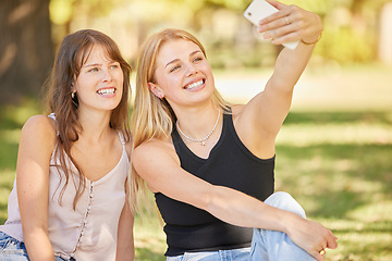 Image showing Selfie, social media and park with a woman friends posing for a picture while sitting on the grass together during summer. Happy, smile and friendship with a female and her friend taking a photograph