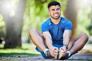 Image showing Fitness, exercise and a man stretching outdoor at park for cardio workout, training and muscle warm up. Happy sports person or athlete in nature for a run and energy for health and wellness goals