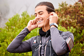 Image showing Sports, fitness and man listening to music in nature for wellness, energy and mental health podcast for training. Professional athlete with audio technology for hiking, exercise or workout in forest