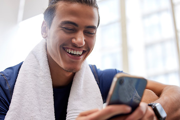 Image showing Man relax, fitness and smartphone in gym, smile and rest after workout, training and typing for social media. Male, athlete and guy with cellphone, break and connection for chatting and with towel