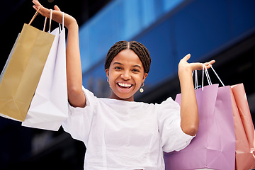 Image showing Portrait, shopping and an excited black woman customer carrying bags in a mall for retail or consumerism. Sale, product and fashion with a young female consumer or shopping buying from a store