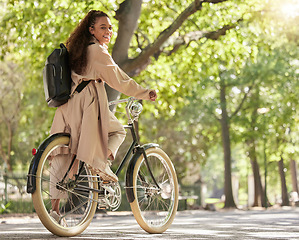 Image showing Bicycle, bike and woman travel in a park outdoors in nature happy and excited on fun ride or commuting. Exercise, wellness and lifestyle female student cycling and relaxing on eco friendly traveling