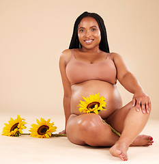 Image showing Black woman sitting with flower, pregnant with smile in portrait and beauty, skincare isolated on studio background. Pregnancy glow, mother and nature with natural cosmetic care, health and wellness