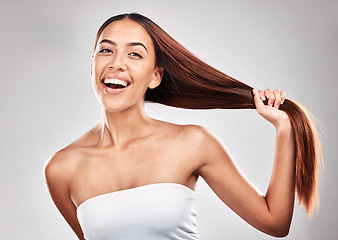 Image showing Happy, woman and portrait of healthy hair in studio for beauty, salon and care on grey background. Face, hold and pull by girl model smile for luxury, strong and shiny keratin results isolated