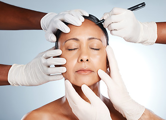 Image showing Woman, face and hands with pen for plastic surgery, beauty or cosmetic process by studio background with surgeon. Senior model, botox and collagen for antiaging, skincare and dermatology with doctor