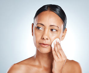 Image showing Face, beauty and senior woman with cotton in studio isolated on gray background. Thinking, cosmetics product and mature female model with facial pad to remove makeup for cleaning, skincare or hygiene