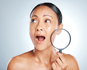 Image showing Face, beauty and surprise of woman with magnifying glass in studio isolated on gray background. Wow, makeup cosmetics and mature female with lens, thinking or shocked after skincare facial treatment