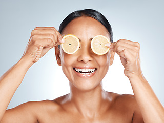 Image showing Lemon, woman face and vitamin c skincare, beauty or clean wellness on studio background. Happy model, smile and citrus fruit of natural cosmetics, detox and facial nutrition of healthy aesthetic glow