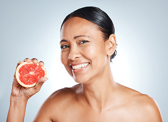 Image showing Grapefruit, happy woman and face portrait for beauty on studio background. Skincare model, smile and citrus fruits for natural cosmetics, detox and nutrition benefits for healthy aesthetic results