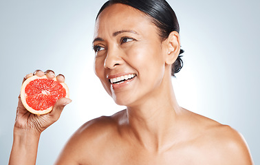 Image showing Grapefruit, skincare and woman on studio background for wellness benefits. Beauty model, face and citrus fruits for natural cosmetics, detox and nutrition for healthy aesthetic results, shine or glow