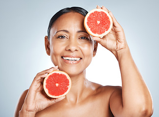 Image showing Grapefruit, portrait and vitamin c skincare of happy woman on studio background. Beauty model, face and citrus fruits for natural cosmetics, detox and nutrition benefits for healthy aesthetic results