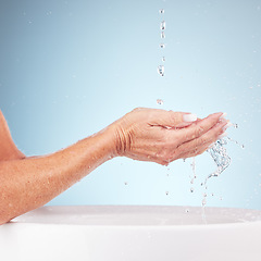 Image showing Senior hands, water and wash for clean hygiene, fresh minerals or splash against a studio background. Hand of elderly holding natural liquid for skin hydration, wellness or skincare in sink or basin