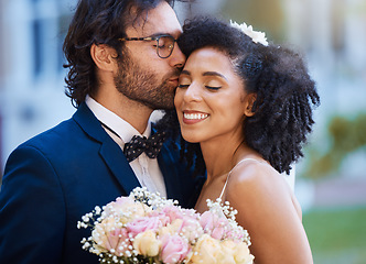 Image showing Care, kiss and couple at wedding happy with romantic outdoor marriage event celebration with flowers. Partnership, commitment and trust embrace of interracial bride and groom with excited smile.