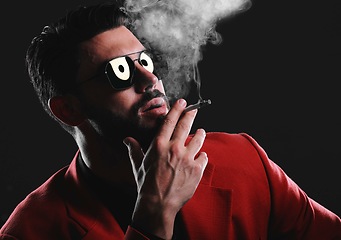 Image showing Fashion, smoke and face with a man model in studio on a dark background wearing a suit for style. Smoking, mafia and edgy with a handsome young male posing on black space holding a cigarette