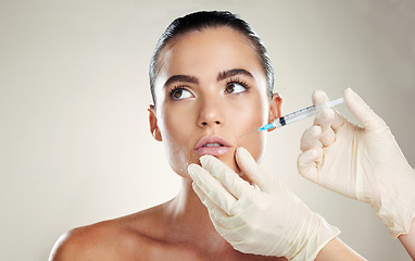 Image showing Skincare, aesthetic beauty and woman with injection in lips from healthcare professional, anti aging treatment in studio. Collagen, mouth and model with facial lip filler syringe on white background.