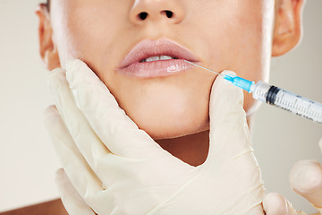 Image showing Skincare, mouth and collagen, woman with injection in lips from healthcare professional, anti aging treatment in studio. Beauty, needle and model with facial lip filler syringe on white background.