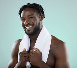 Image showing Man, face portrait and skin in studio with towel for hygiene and grooming. Healthy and happy black person on blue background for facial glow, cosmetics and self care with dermatology skincare brand