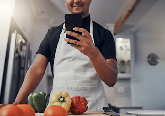 Image showing Cooking vegetables, phone and man in kitchen while online with house wifi connection for learning on food blog. Chef person with mobile app for online recipe for home food for vegan or healthy eating