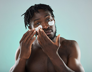 Image showing Eye patch, man and face portrait for skincare, beauty and dermatology in studio. Healthy black person on blue background for facial glow, clean skin and self care with cosmetic collagen mask