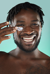 Image showing Skincare, wellness and black man with face cream in a studio with a beauty, health and natural skin routine. Portrait, cosmetic and African guy with facial spf, lotion or creme by a blue background.