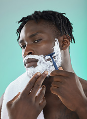 Image showing Shaving face with skincare cream, black man with razor on studio background and on smooth facial hair growth. Confident young model grooming, body hygiene and cleaning beard with cosmetic product