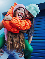 Image showing Friends, city fashion and piggyback girl with outdoor adventure, funny and comic face with happiness together. Gen z women, metro and blue background for trendy clothes, smile and happy in street