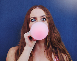 Image showing Comic, bubblegum and portrait of girl on blue background with silly, funny and crazy facial expression in city. Freedom, fashion and face of woman with candy bubble for trendy, cool and urban style