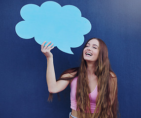Image showing Happy woman holding a chat board with mockup space standing by a blue wall with a sign. Gen z, happiness and young female with a speech bubble with mock up or copy space for marketing or advertising.