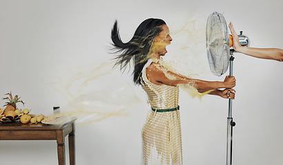 Image showing Art, juice and summer splash, woman with refreshing wind in face from fan and fruit for cocktail drinks. Air con, heat and fresh squeezed orange spray blowing with scream in creative advertisement.