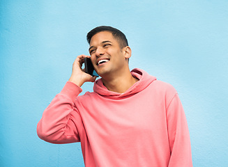 Image showing Casual man, phone call and laughing in communication standing isolated on a blue background. Happy male, person or guys with pink jacket in discussion, conversation or talking on mobile smartphone