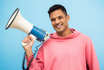 Image showing Megaphone, man and portrait of a male speaker ready for justice, equality and human rights speech. Smile, happiness and isolated blue background in a studio smiling and excited about social change