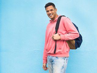 Image showing Portrait, university and man student with backpack in studio, happy and smile on blue background. Face, handsome and college student excited about education, vision and career goal while isolated