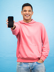 Image showing Happy man, portrait or phone screen mockup on isolated blue background for social media, app or web design. Smile, student or model with technology mock up for city contact communication or branding