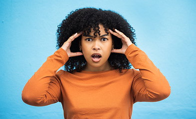 Image showing Wow, surprise and portrait with a black woman in shock standing on a blue background in studio. Omg, confused and face with an attractive young female looking shocked or surprised indoor