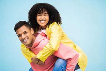 Image showing Happy people, bonding and piggyback portrait on isolated blue background in travel, date or fun game. Smile, man and carrying black woman in playful, silly or goofy trust for love couple in support