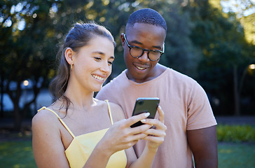 Image showing Interracial, meme and couple with a phone in a park, funny communication and laughing at social media. Comic, streaming and black man and woman reading a joke on a mobile in nature of France