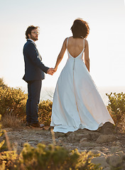 Image showing Wedding, nature or a couple of friends holding hands on a mountain in a romantic celebration of love. Interracial marriage, black woman and happy man in a commitment as bride and groom at sunset