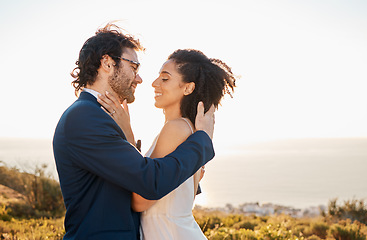 Image showing Love, wedding and bride with groom on mountain for marriage ceremony, commitment and celebration. Romance, happiness and interracial couple bonding, kiss and smile with ocean, nature and outdoors