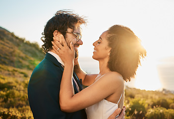 Image showing Love, wedding and couple on mountain kiss for marriage ceremony, commitment and celebration. Affection, romance and interracial bride and groom bonding, happy and smile with ocean sunset in Italy