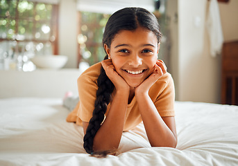 Image showing Portrait, children and bedroom with an indian girl lying on her bed at home over the weekend to relax. Kids, face and smile with a happy female child resting or relaxing alone in her house