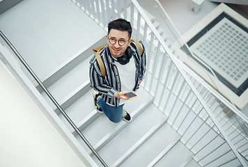 Image showing Happy, student or startup man with phone on staircase for internet research, social media content or networking. Smile, top or employee nerd on smartphone for strategy, blog review or communication