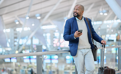 Image showing Businessman, phone and luggage at airport for travel, journey or checking flight times or destinations. Happy black man, person or employee holding smartphone for schedule, traveling or work trip