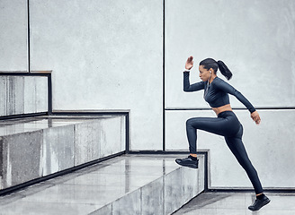 Image showing Fitness, training and woman running on stairs for health, cardio and morning workout in the city. Focus, commitment and athlete doing exercise on steps for sports, motivation and sprinting in France