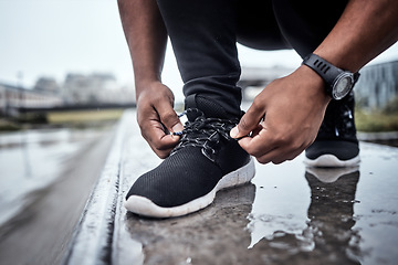 Image showing Fitness, shoes and running with a sports man tying his laces for an outdoor cardio or endurance workout. Exercise, footwear and training with a male athlete or runner fastening his shoelaces outside