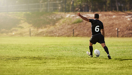 Image showing Rugby, player and kick a sports ball on a field during practice, exercise or training outdoors. Athlete, sportsman and man during a game taking a penalty for a championship match on summer day